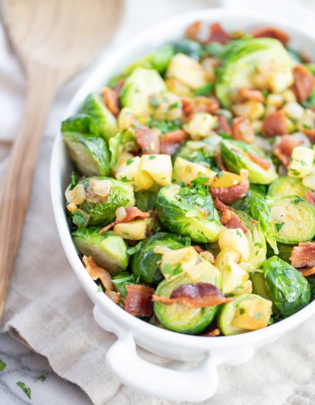 brussels sprouts withbacon and apples in a white dish