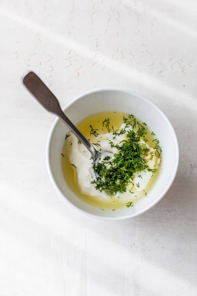 making creamy dill sauce in a small bowl
