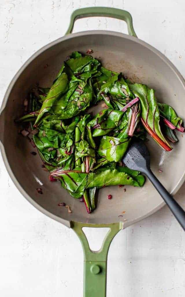 sautéing beet greens in a large skillet