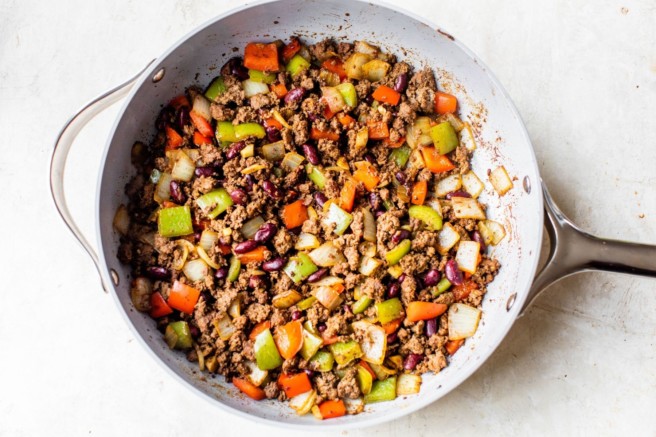 Veggies and ground meat cooked in a skillet.