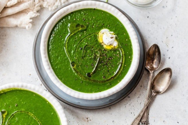 spinach soup served garnished with black pepper and Greek yogurt