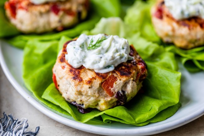 Greek Turkey burgers topped with sauce.