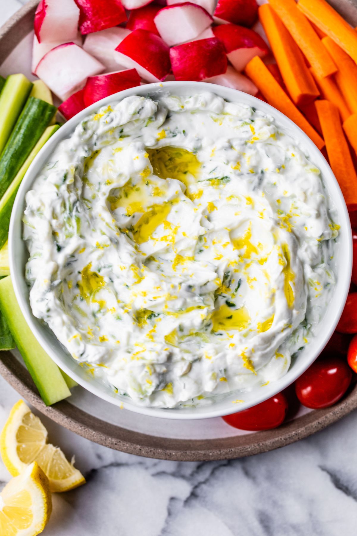 Tzatziki sauce garnished with olive oil and served with vegetables.