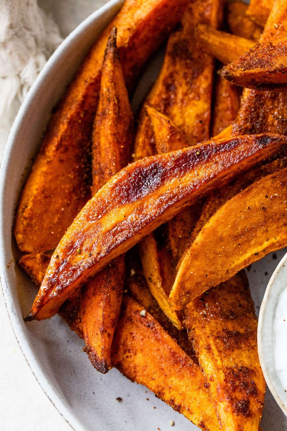 Closeup view of sweet potato wedges on a plate.