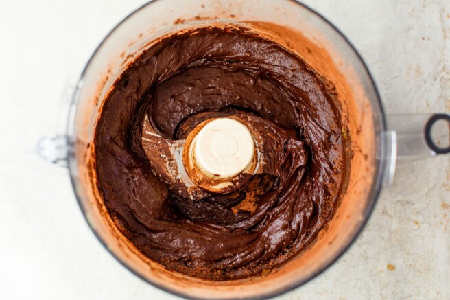 Adding cocoa powder to avocado to make pudding.