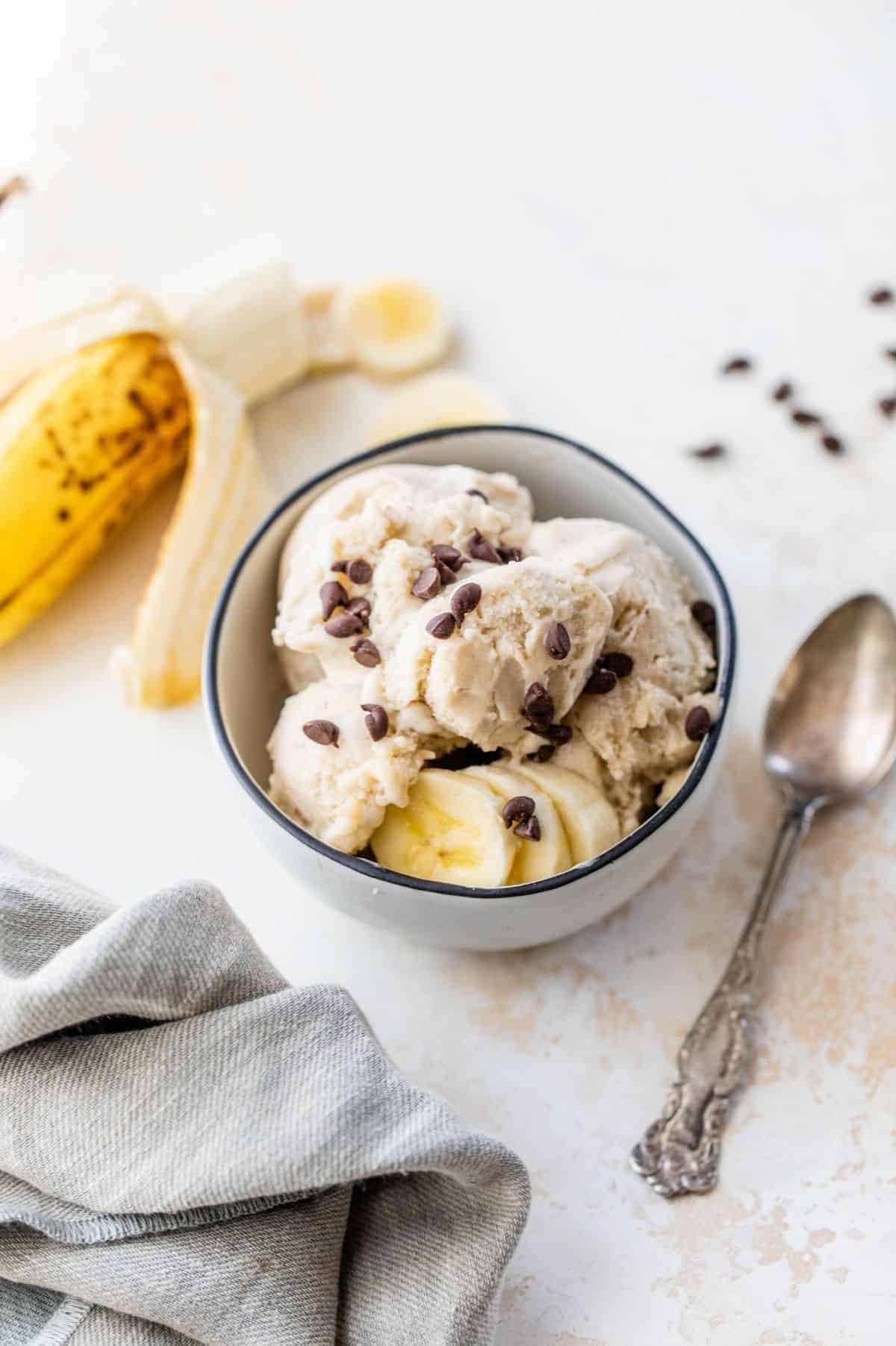 scoops of banana ice cream in a small bowl near a banana