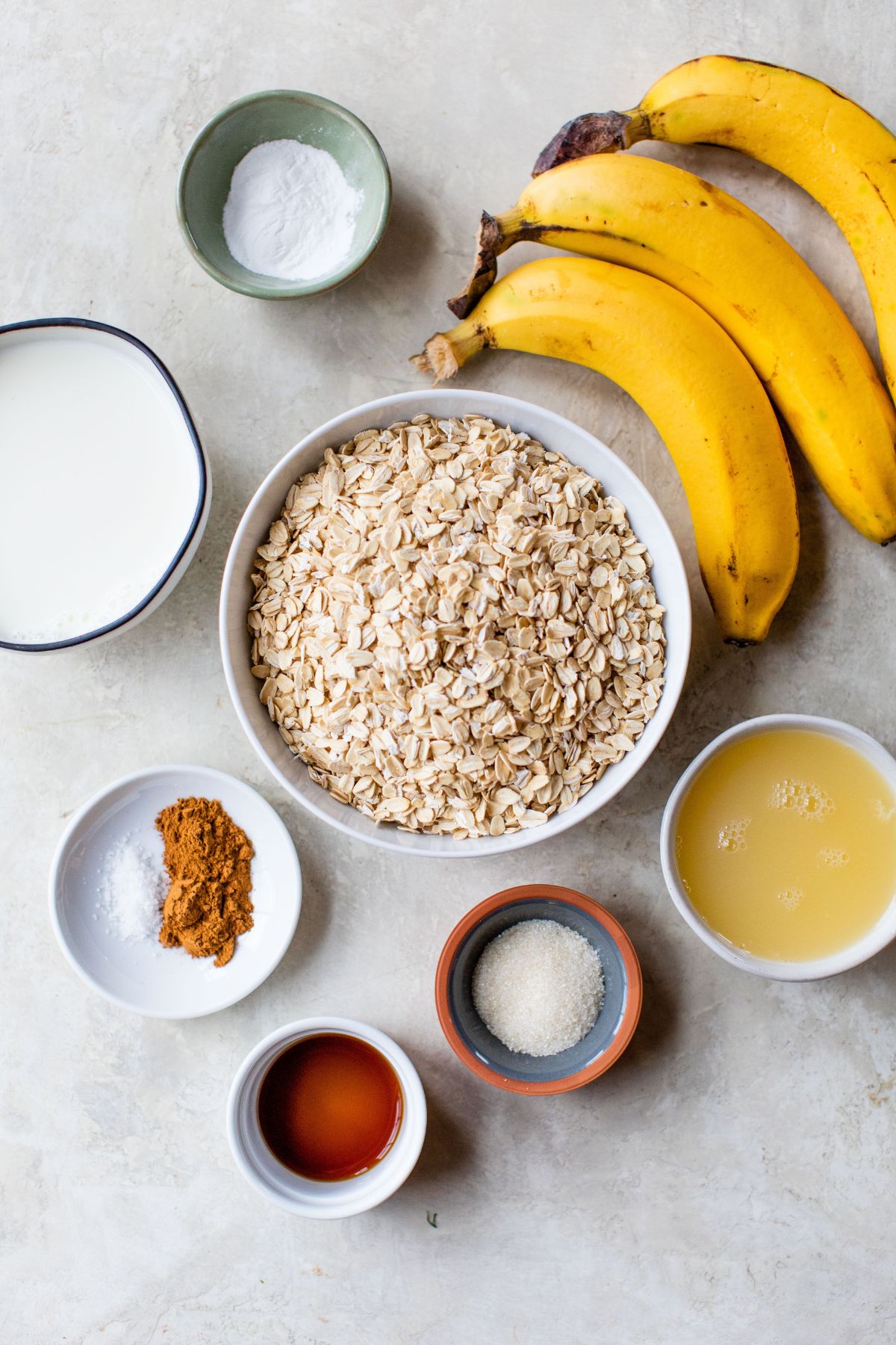 Rolled oats, bananas and other ingredients portioned into small bowls.