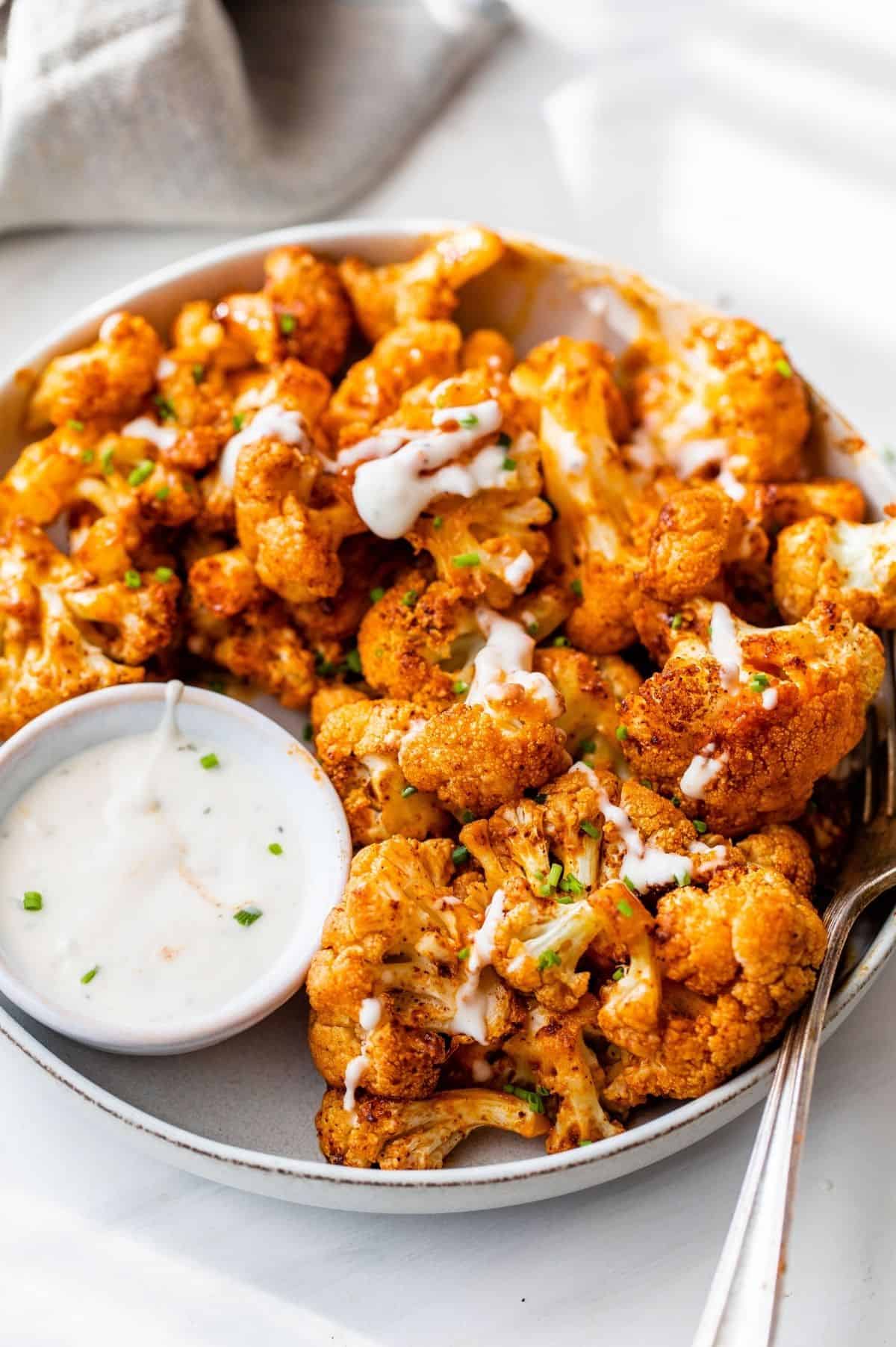 buffalo cauliflower bites served with a dipping sauce