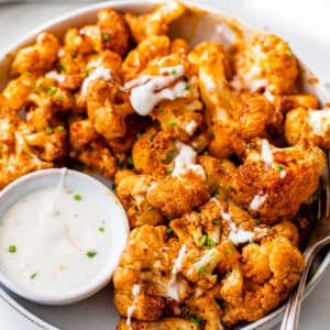 baked cauliflower bites on plate with sauce