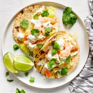 shrimp tacos topped with fresh cilantro and served with lime