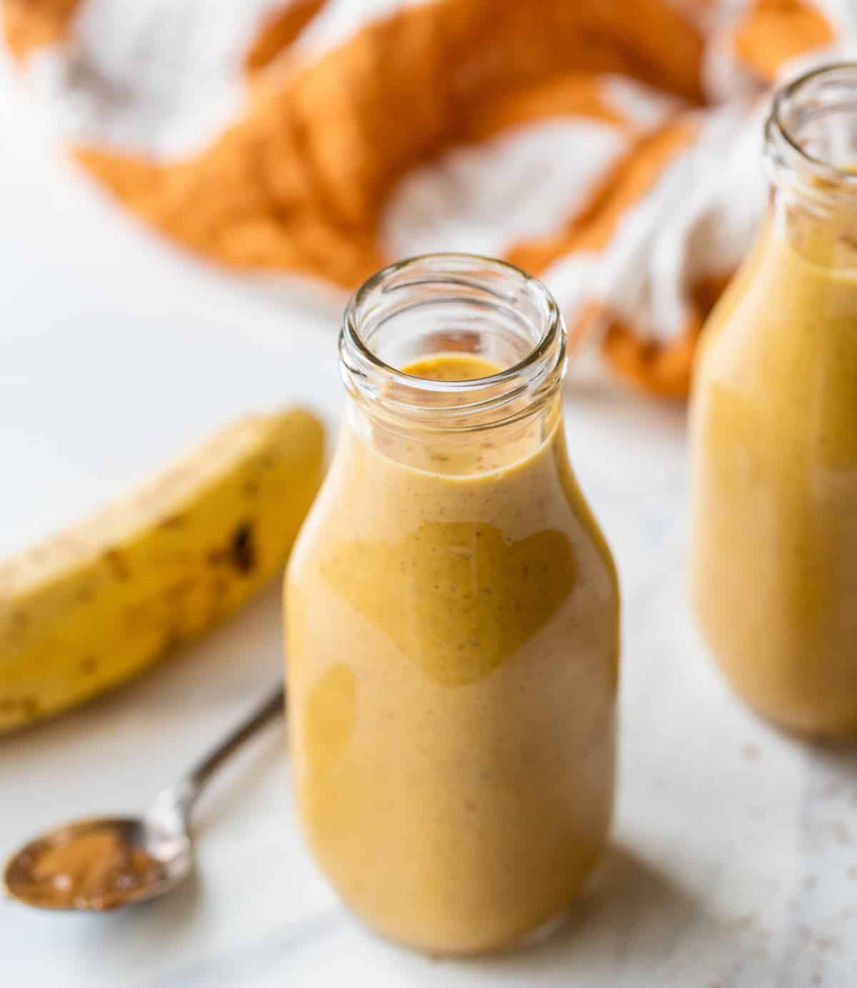 vegan pumpkin pie smoothie in glass carafe with a banana