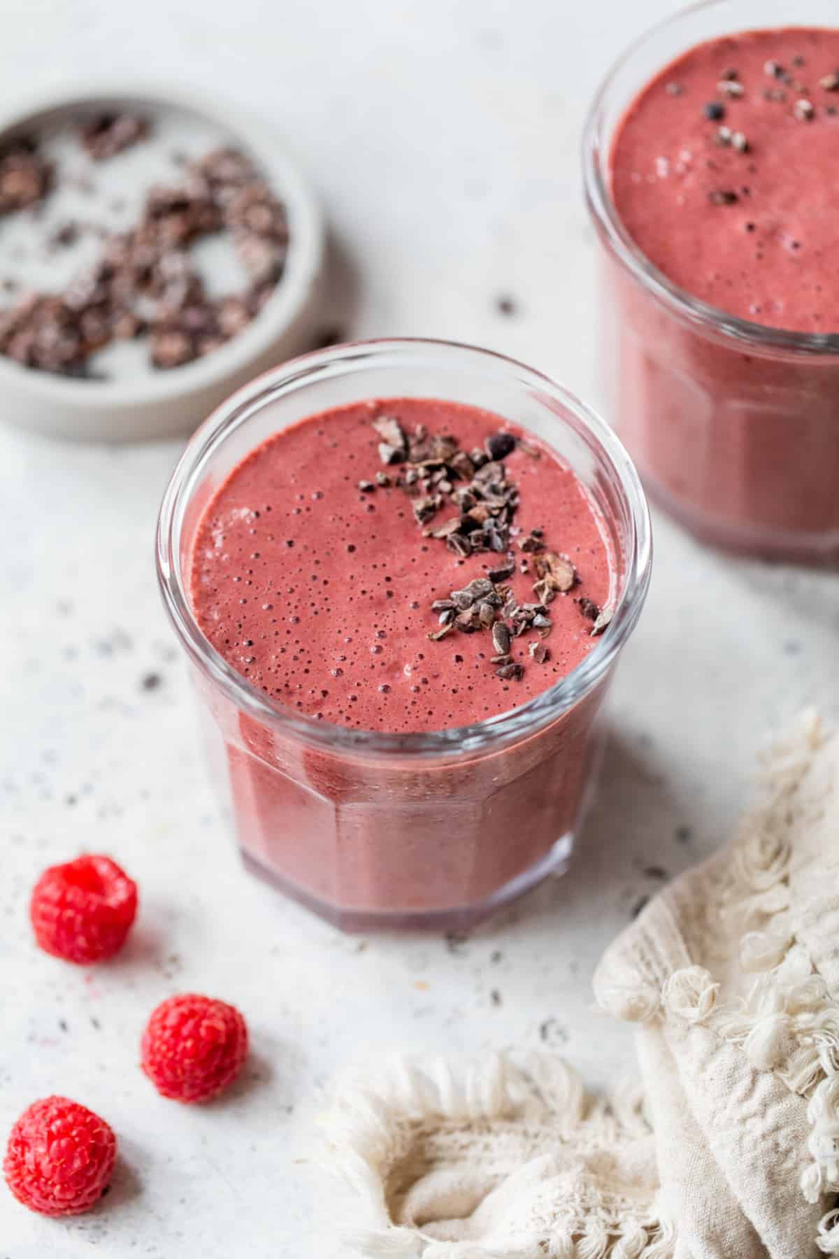 chocolate raspberry smoothies topped with cacao nibs