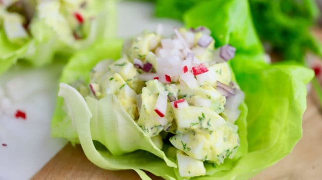 classic egg salad in a lettuce cup topped with diced radish and celery