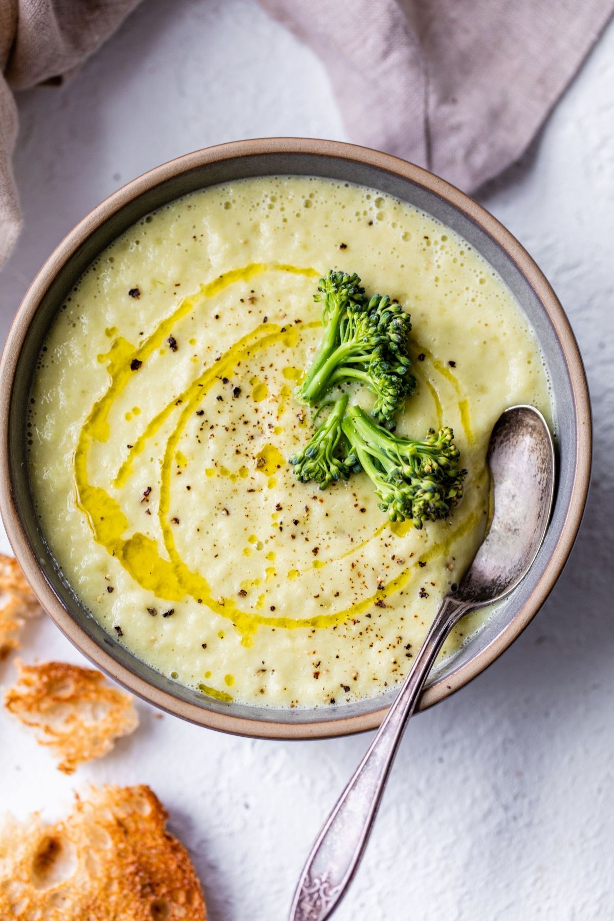 Broccoli stem soup in a bowl with a spoon.