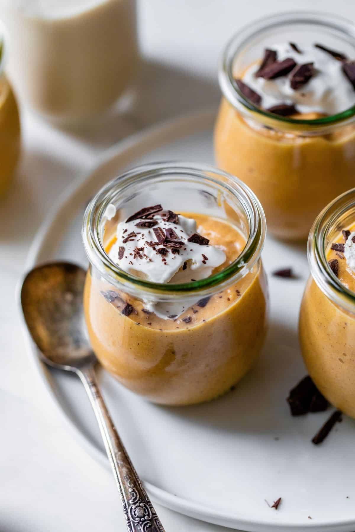 pumpkin pie mousse topped with a dollop of whipped cream and chocolate shavings