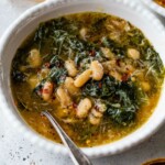 Escarole and beans in a bowl with a spoon.