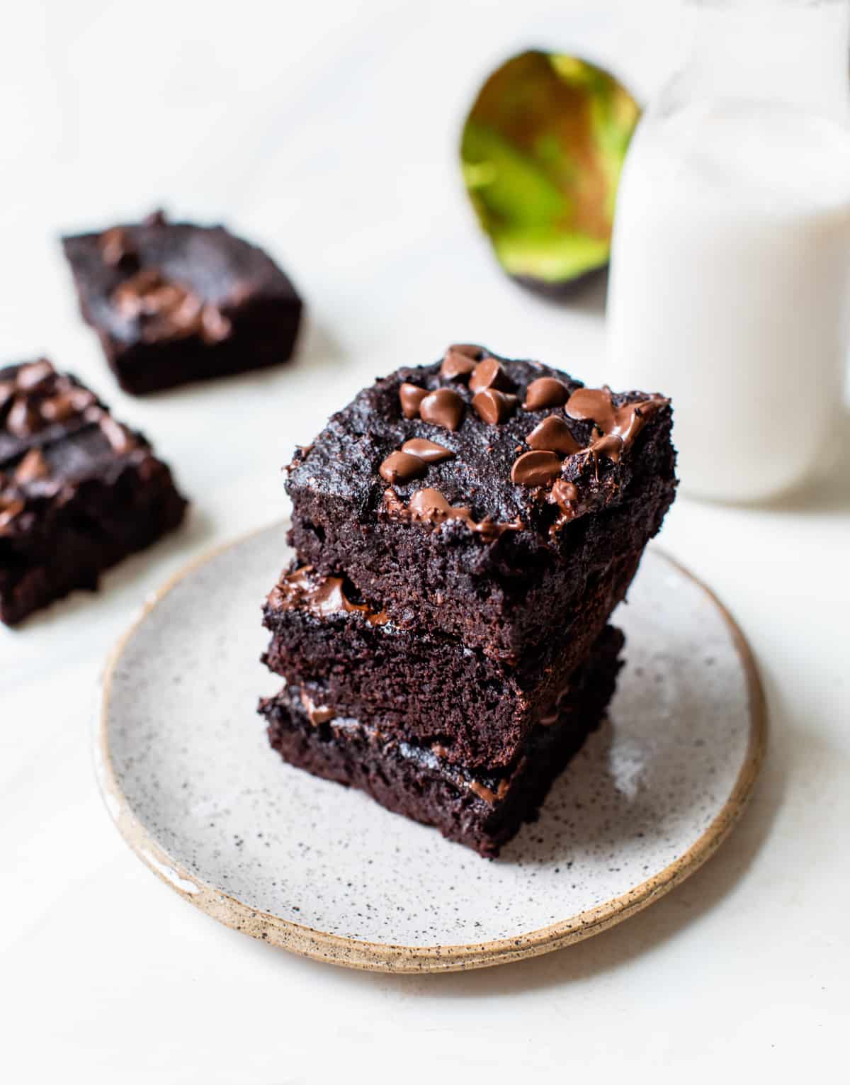 fudgy avocado brownies stacked up on a white plate