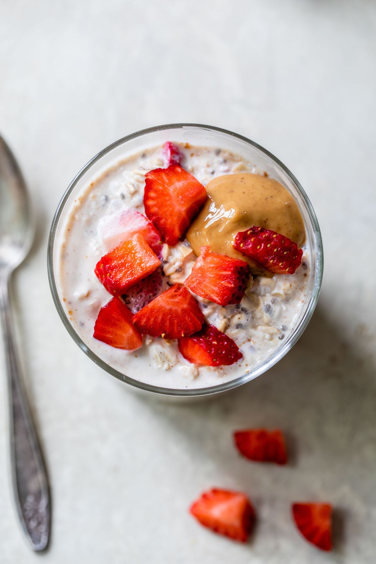 Top view of overnight oats topped with chopped strawberries and a dollop of peanut butter.
