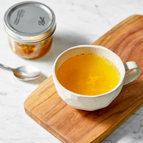ginger turmeric tea in a mug on a wooden board