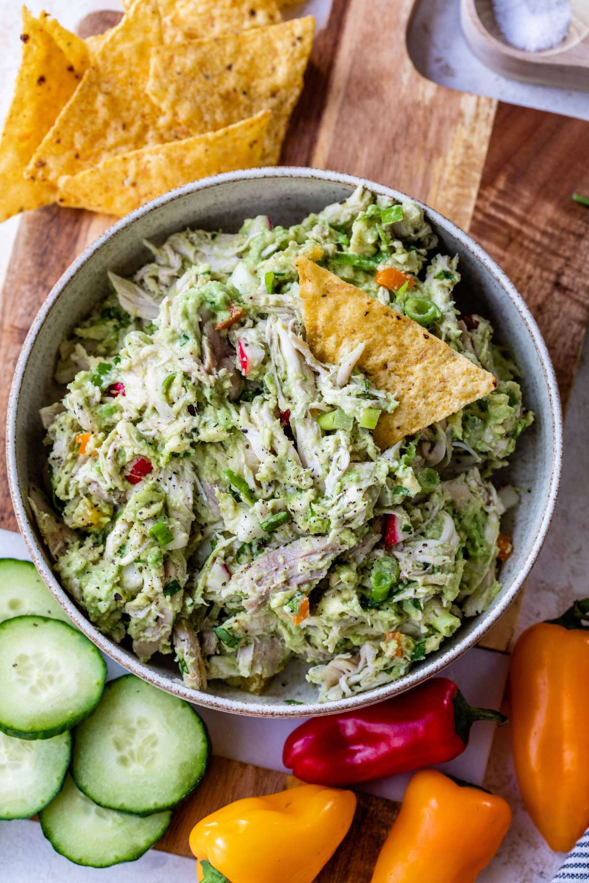 Avocado chicken salad served with chips and veggies.