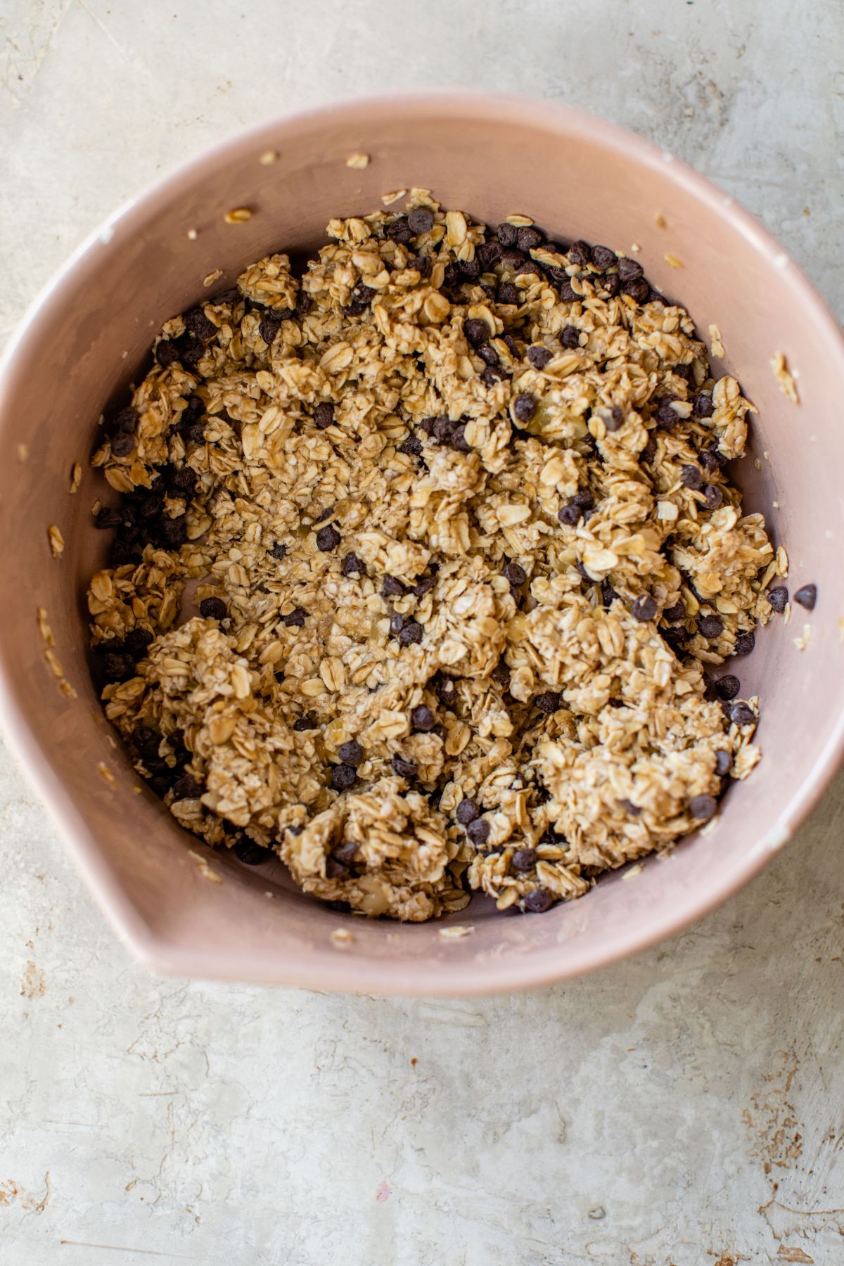 An oat, banana, chocolate chip batter in a bowl.