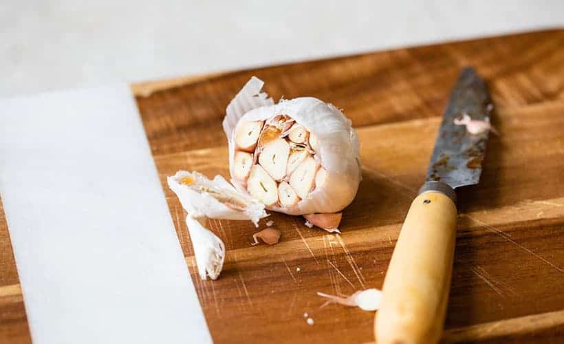cutting roasted garlic in order to roast it in foil