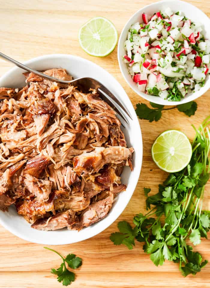 pulled pork in white bowl with lime and cilantro 