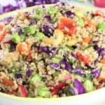 a bowl of quinoa with Asian flavors tossed with edamame, red bell pepper, and red cabbage