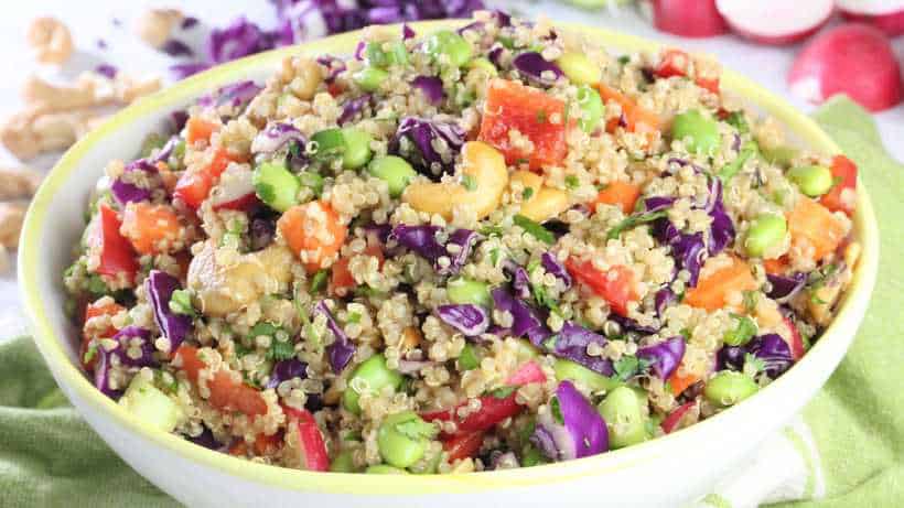 a bowl of quinoa with Asian flavors tossed with edamame, red bell pepper, and red cabbage