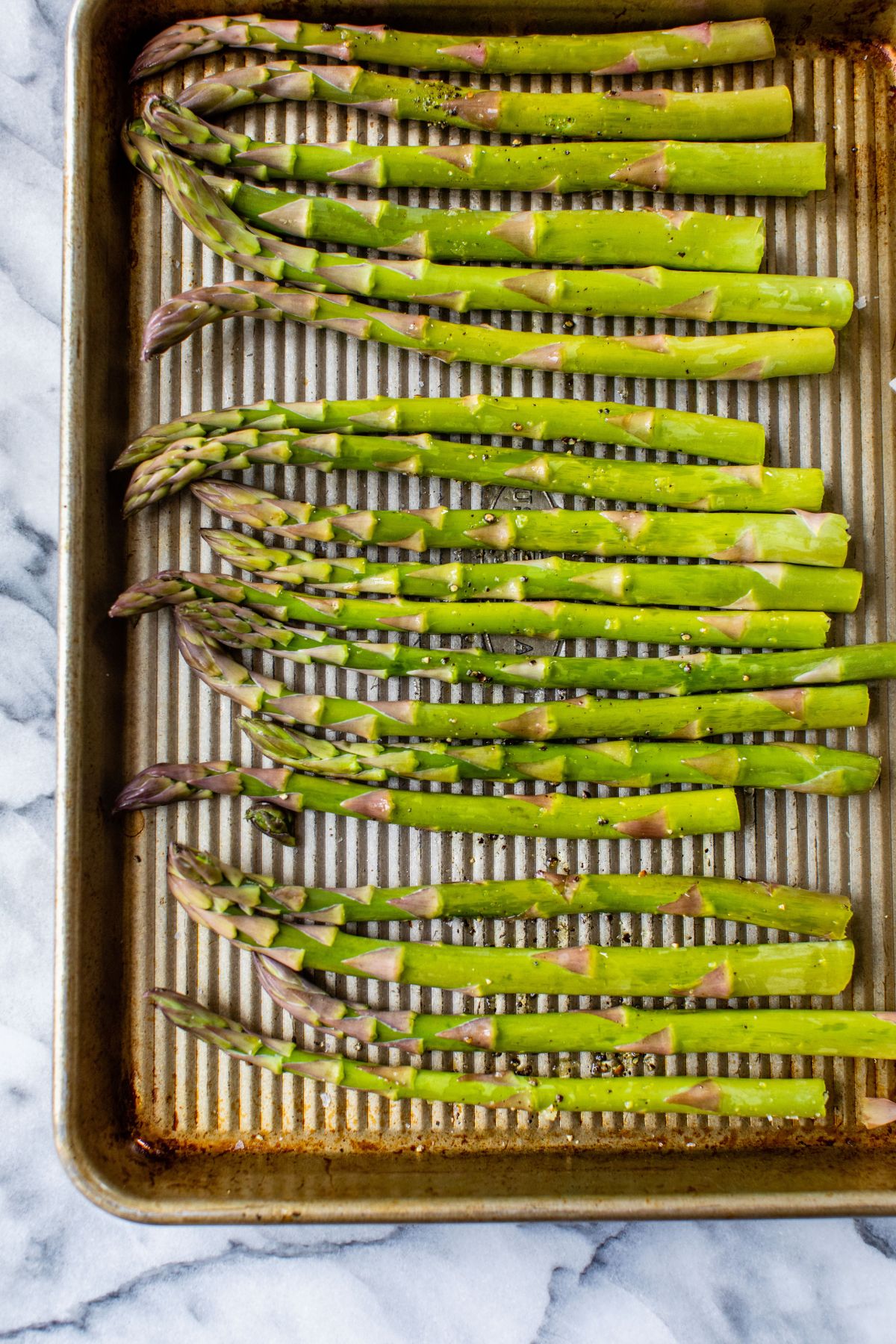 Asparagus spears on a sheet pan.