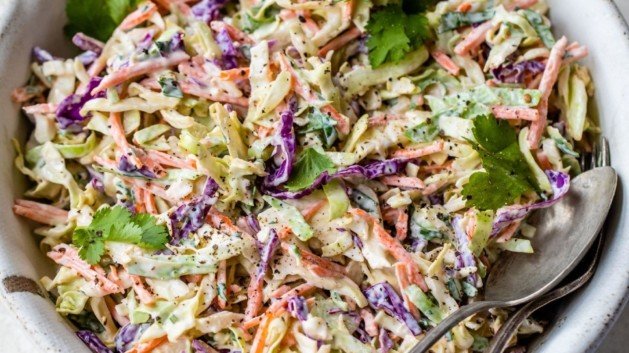 Coleslaw served in a large bowl with a serving spoon.