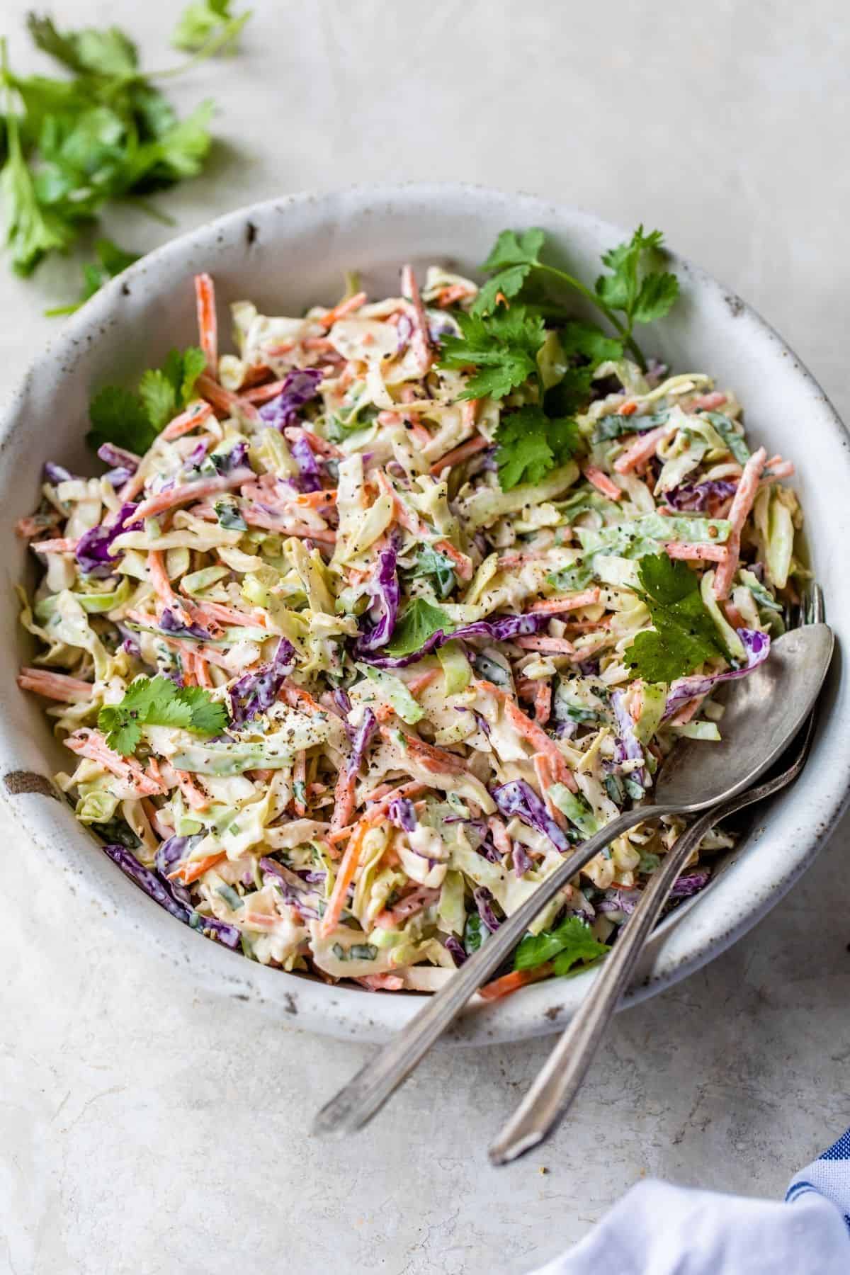 Coleslaw served in a large bowl with a serving spoon.