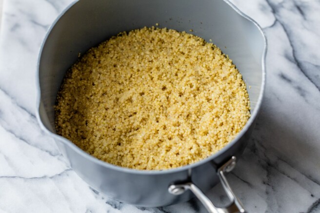 Quinoa cooking with water in a saucepan.