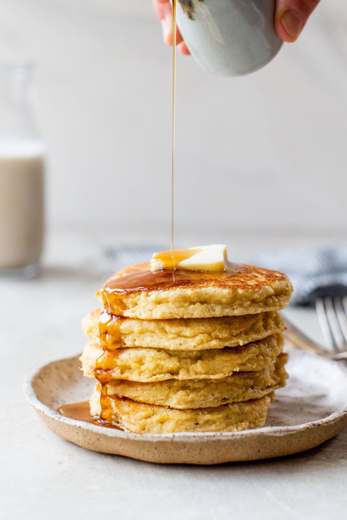 Drizzle maple syrup over a stack of pancakes.