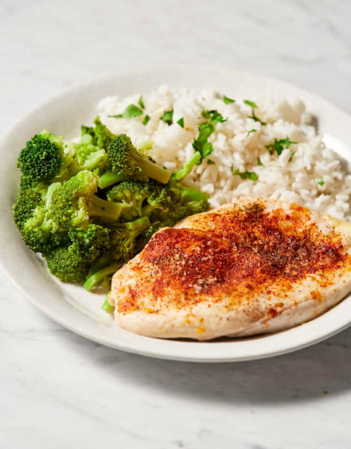 baked chicken breast served with broccoli and rice