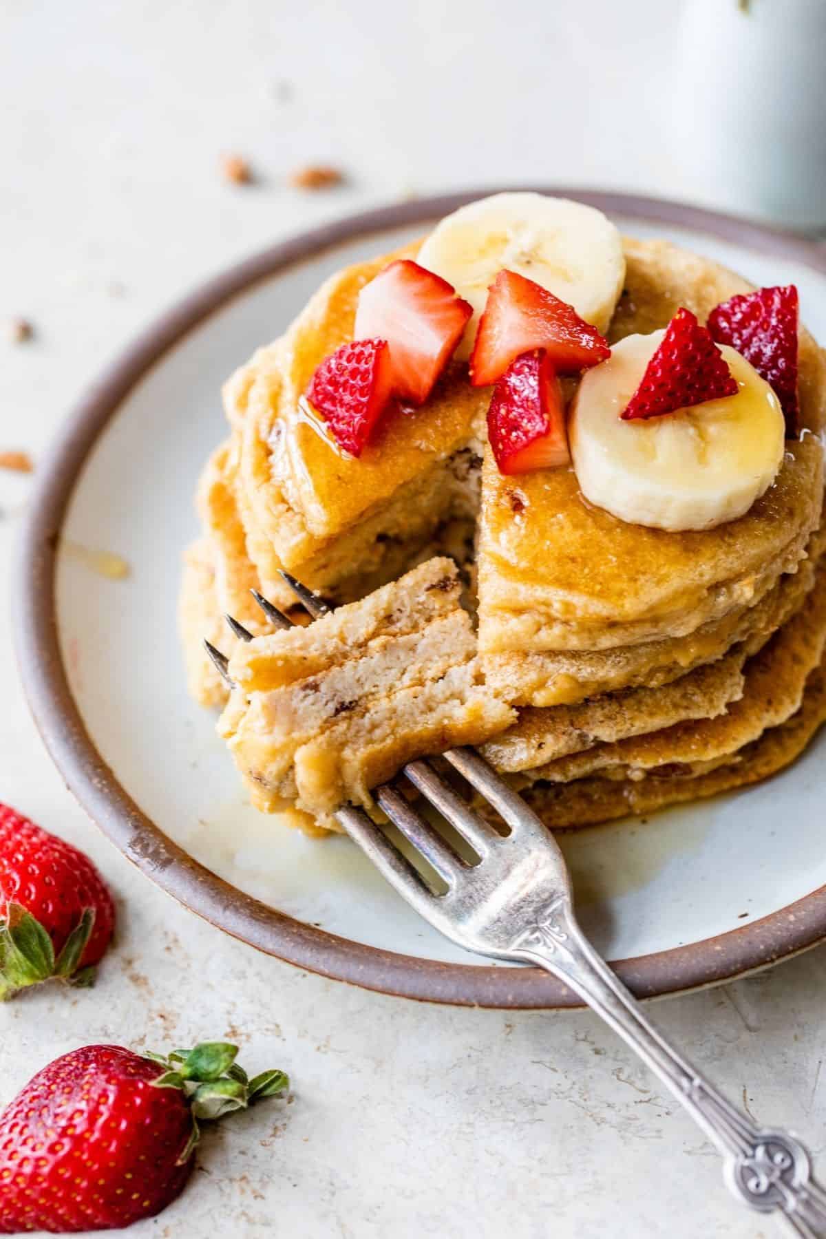 coconut flour pancakes topped with strawberries and banana slices