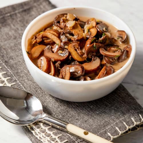 sliced creamy mushrooms in a small white bowl