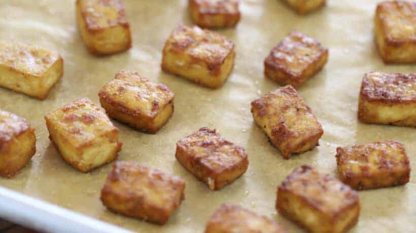 crispy baked tofu cubes on a rimmed baking sheet