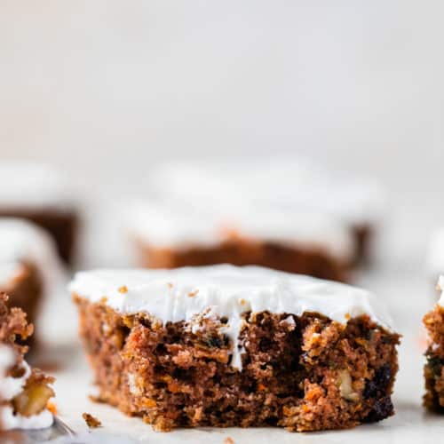 slice of gluten free carrot cake topped with cream cheese icing
