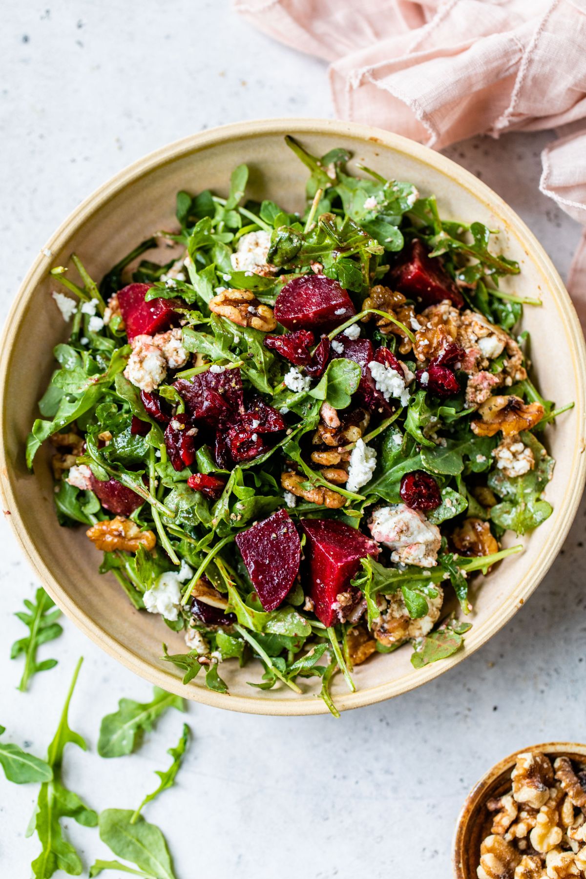 Arugula salad with steamed beets and goat cheese in a bowl.