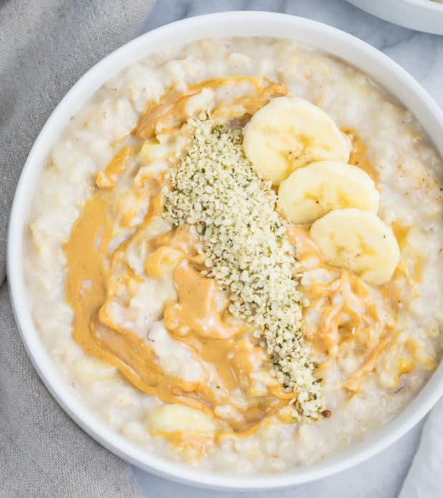 bowl of oats topped with bananas, peanut butter and hemp seeds