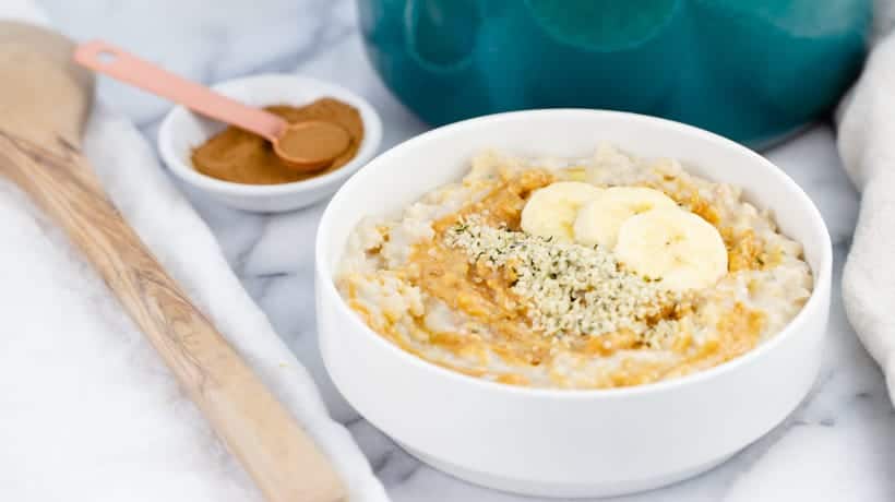 creamy bowl of oatmeal topped with banana and peanut butter