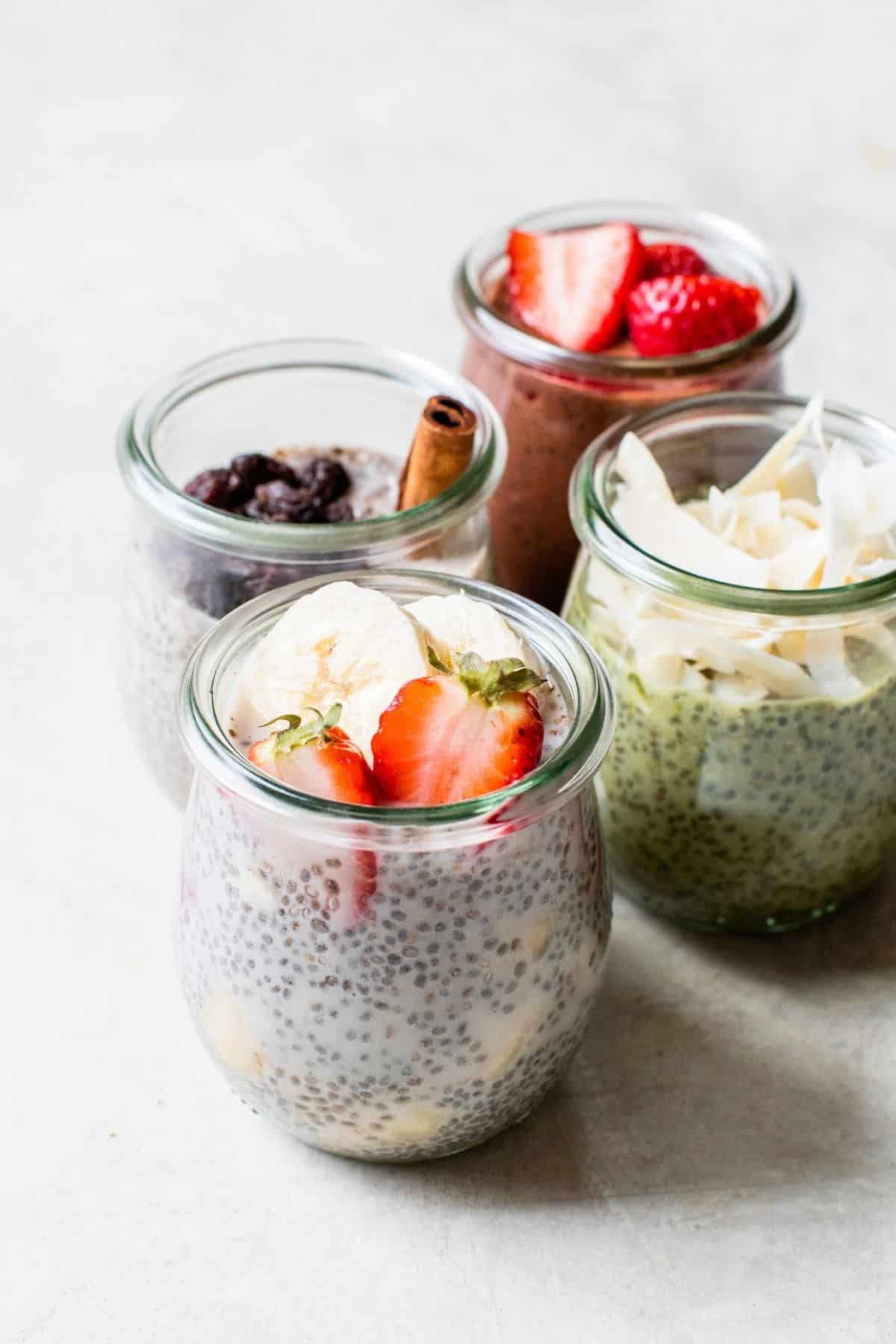 small jars filled with different types of chia seed pudding