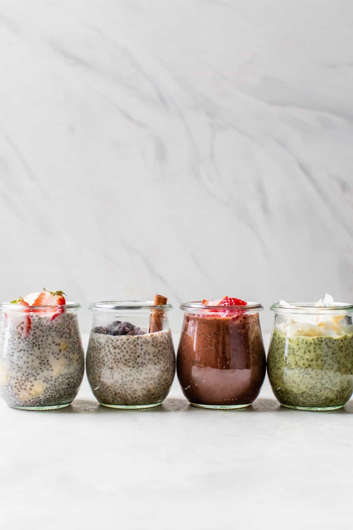 4 glass jars lined up with chia pudding