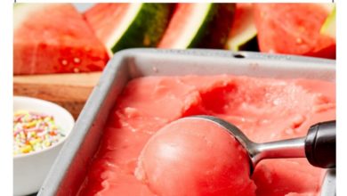 scooping watermelon ice-cream out of a loaf pan with an ice cream scoop