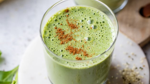 green breakfast smoothie topped with cinnamon