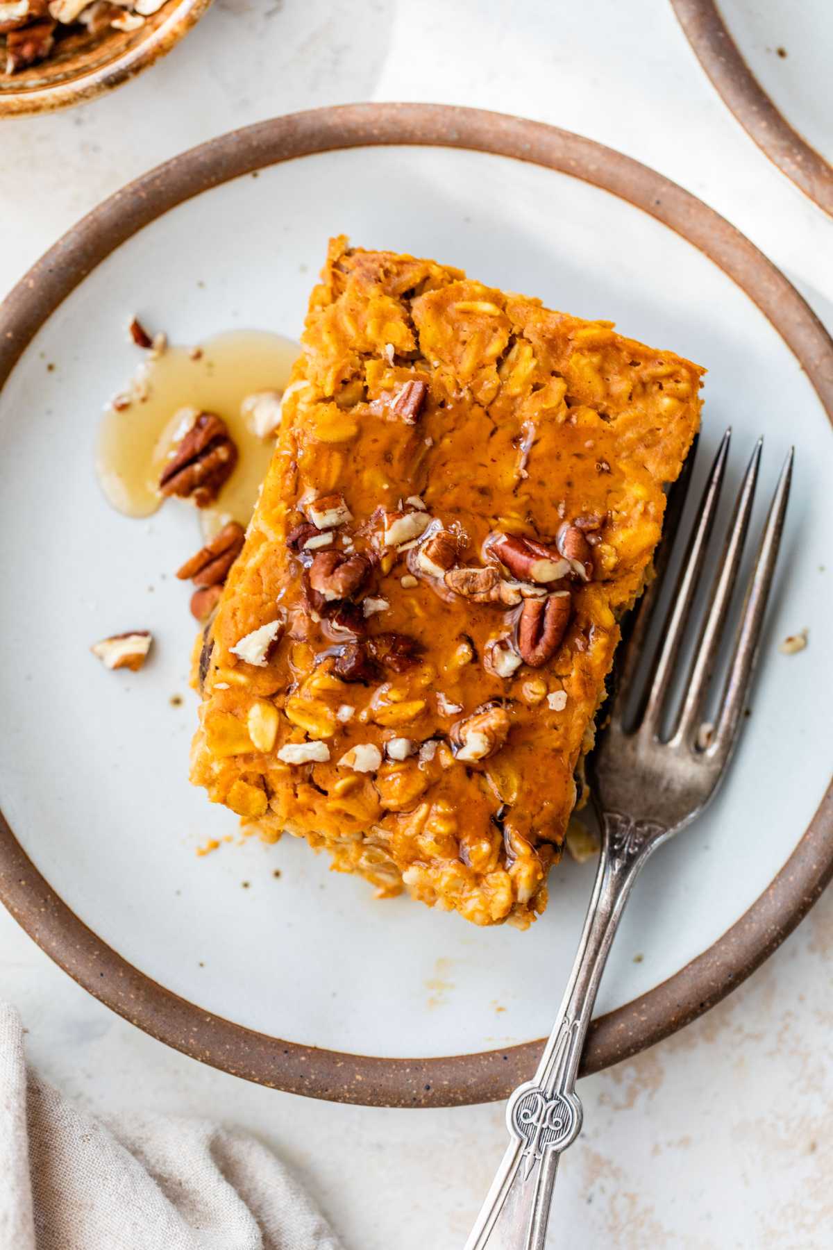 Serving of baked pumpkin oatmeal on a white plate.
