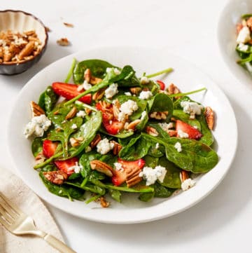 strawberry spinach salad in a white bowl