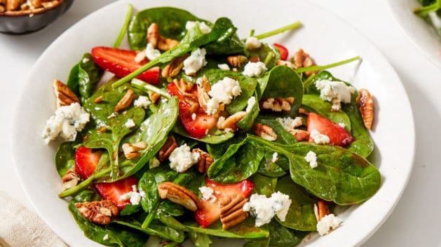 strawberry spinach salad in a white bowl