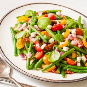green bean and tomato salad with feta cheese in a bowl
